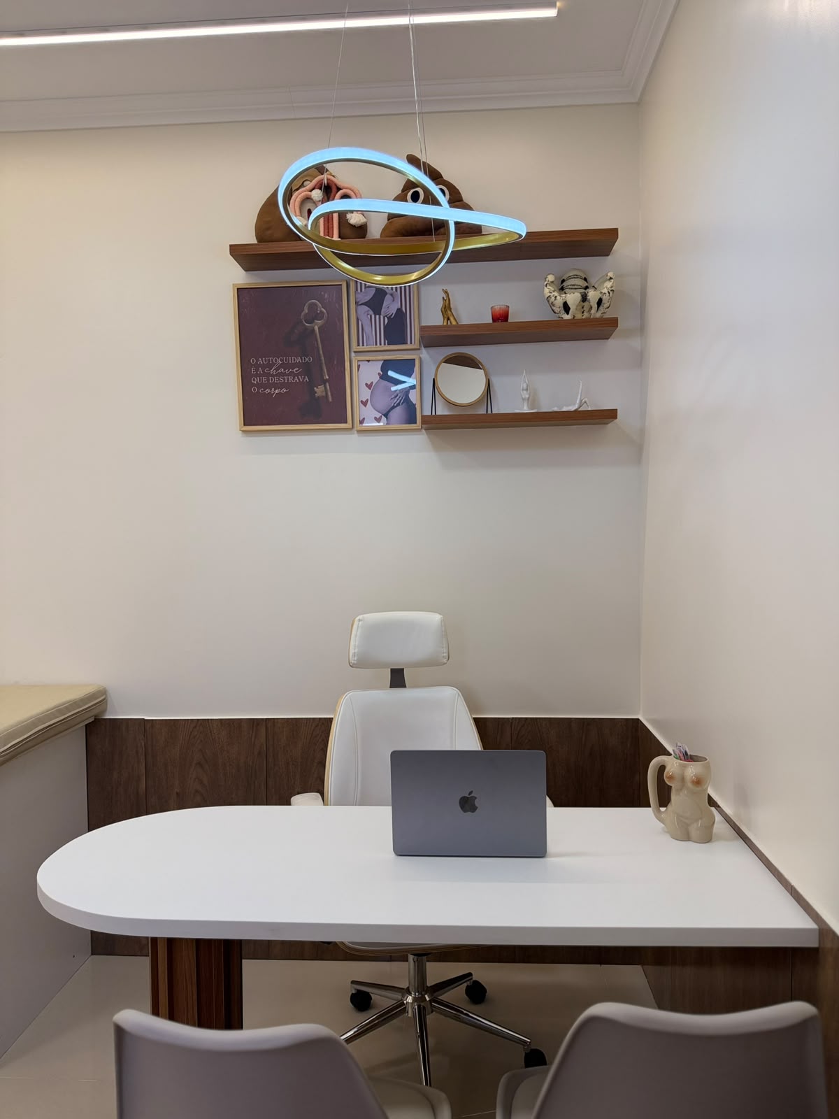 Detalhe da decoração do consultório com quadros e iluminação suave